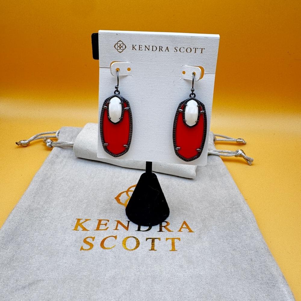 EUC gunmetal Emmy with white MOP and red glass.